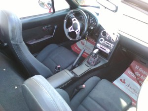 bag rattet sidder man faktisk rimelig godt omend lidt tæt hvis man er høj som jeg. Men med taget nede er blinde vinkler næsten ikke eksisterende og med klaplygterne slået op føles MX5 som en rigtig lille motor frø der hopper afsted i traffiken 